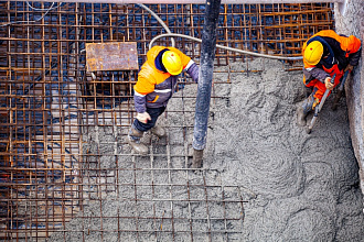 бетонщик заливает бетонную плиту